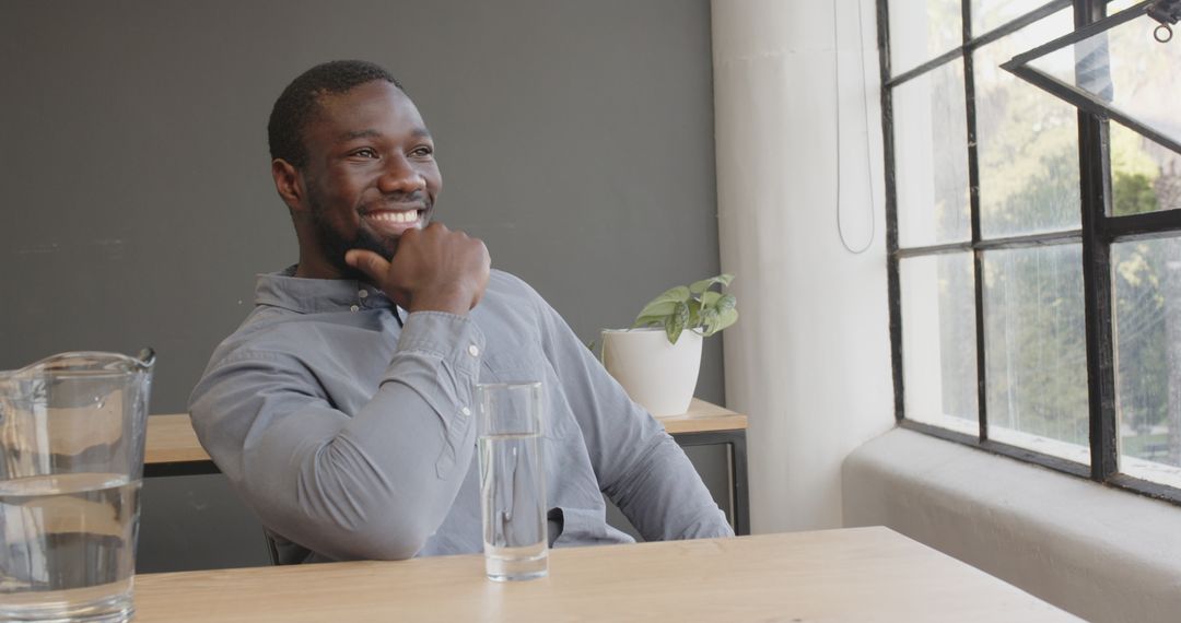 Smiling Businessman Taking Water Break at Modern Office Desk