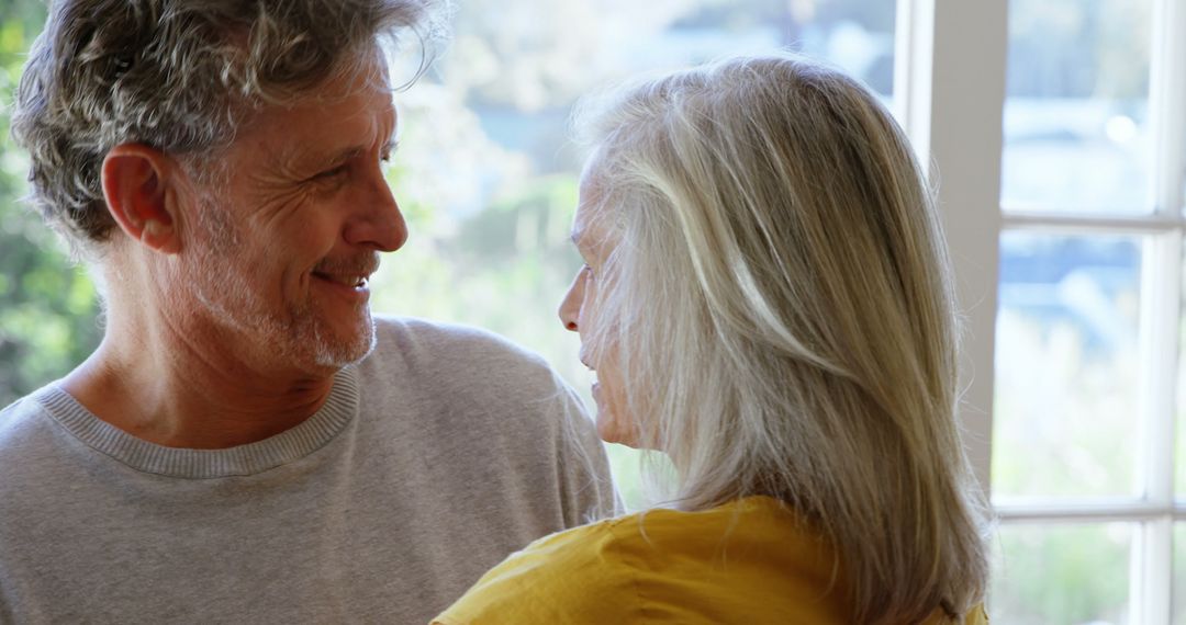 Joyful Senior Couple Embracing by Bright Window