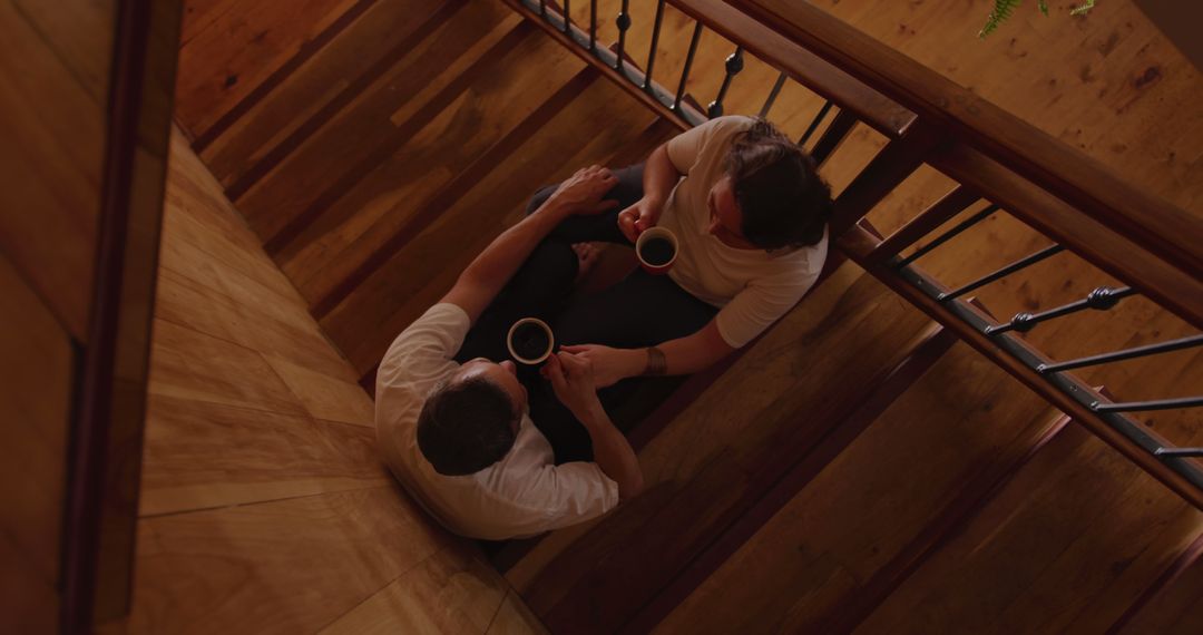 Overhead View of Two Men Sharing Coffee on Stairs - Free Images, Stock Photos and Pictures on Pikwizard.com