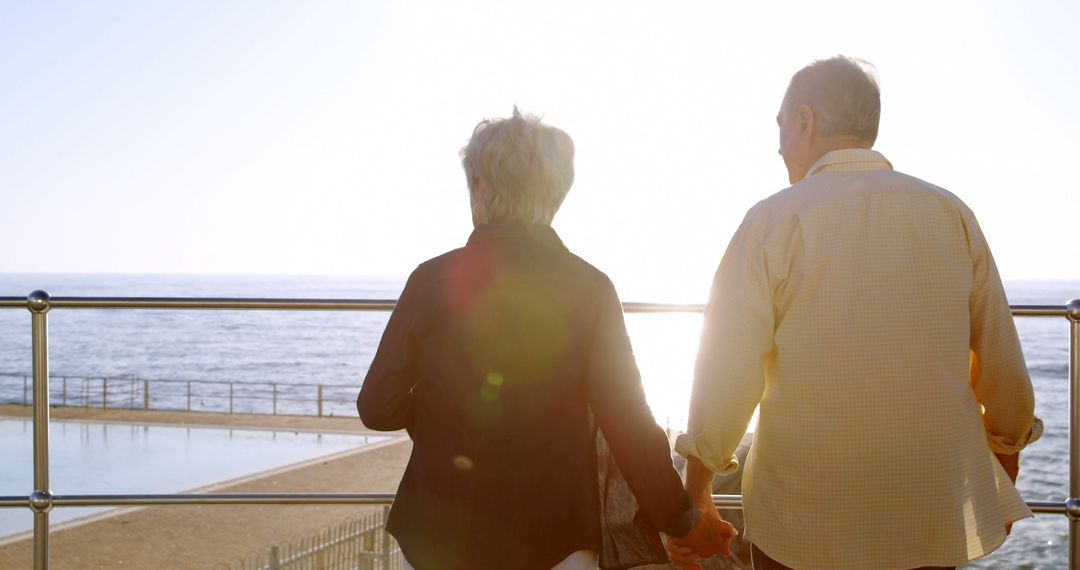 Senior Couple Holding Hands and Enjoying Ocean View at Sunset - Free Images, Stock Photos and Pictures on Pikwizard.com