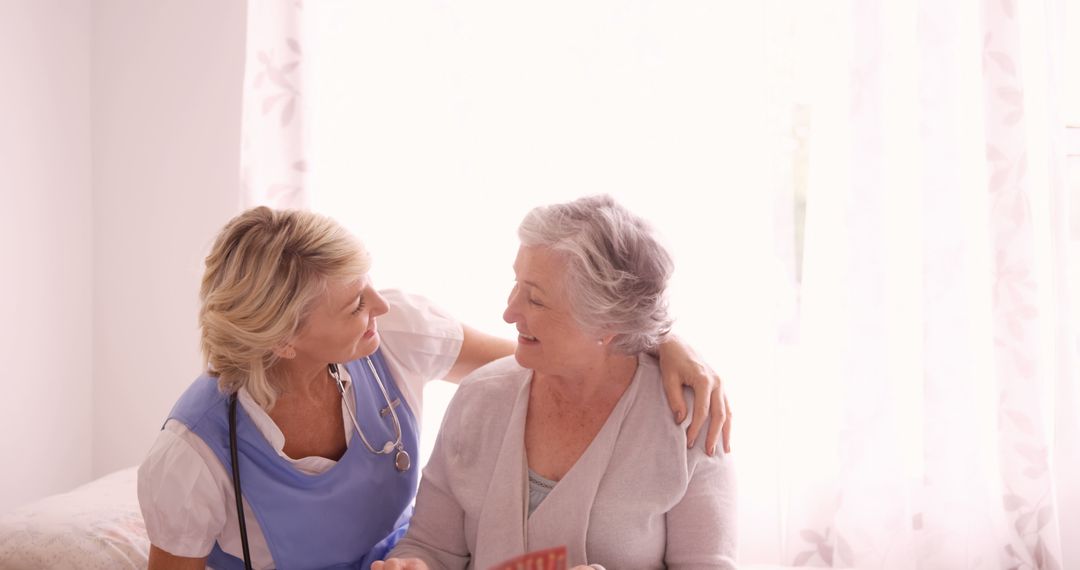 Compassionate Nurse Interacting with Elderly Patient in Sunny Room - Free Images, Stock Photos and Pictures on Pikwizard.com