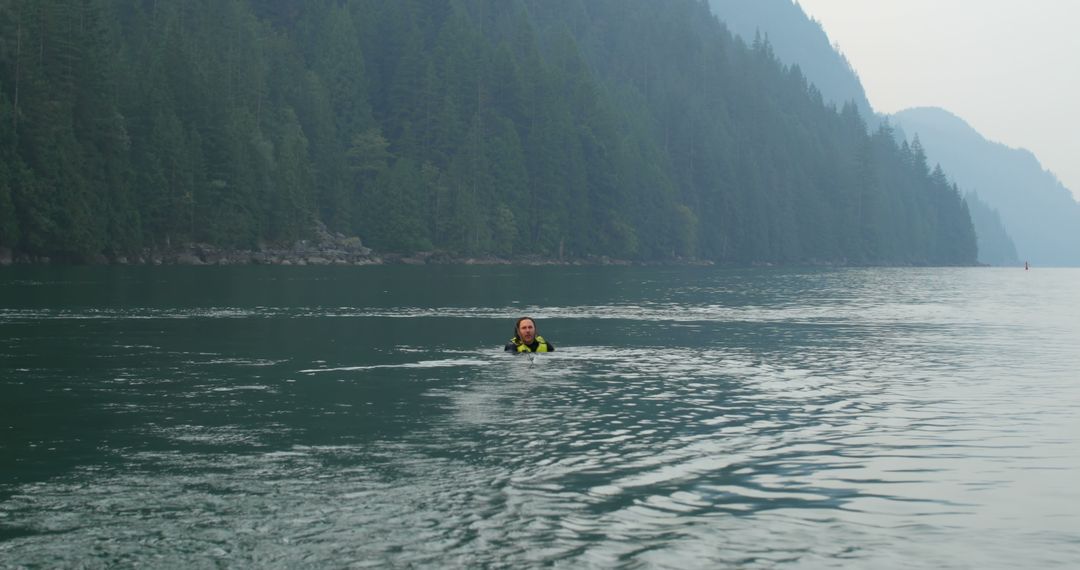 Person Swimming in Misty Mountain Lake - Free Images, Stock Photos and Pictures on Pikwizard.com