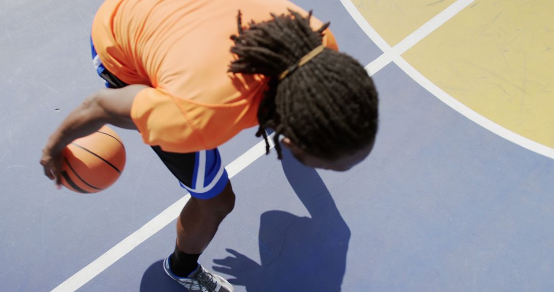 Basketball Player Dribbling on Outdoor Court at Daytime - Free Images, Stock Photos and Pictures on Pikwizard.com