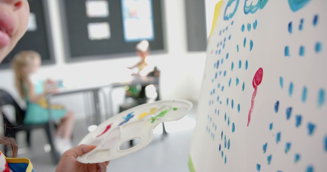 Child Creating Art in Classroom with Paint Palette