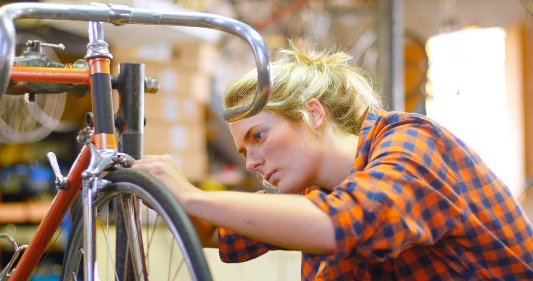 Female mechanic fixing bicycle tire in workshop - Free Images, Stock Photos and Pictures on Pikwizard.com