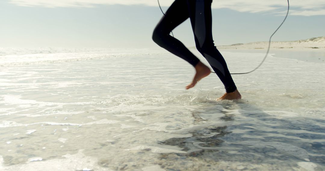 Person Running on Beach Shore with Surfboard String - Free Images, Stock Photos and Pictures on Pikwizard.com