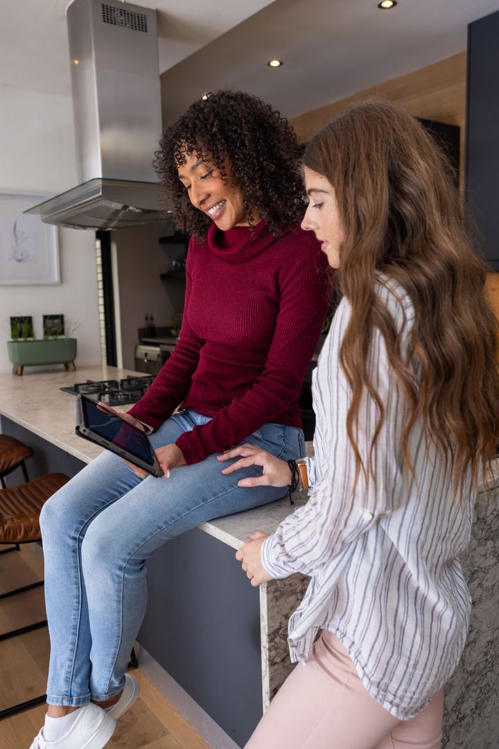 Diverse Friends Engaging with Tablet in Modern Kitchen