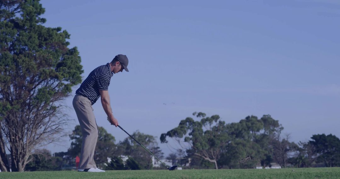 Golfer Aligning Precision Shot on Scenic Golf Course Tee