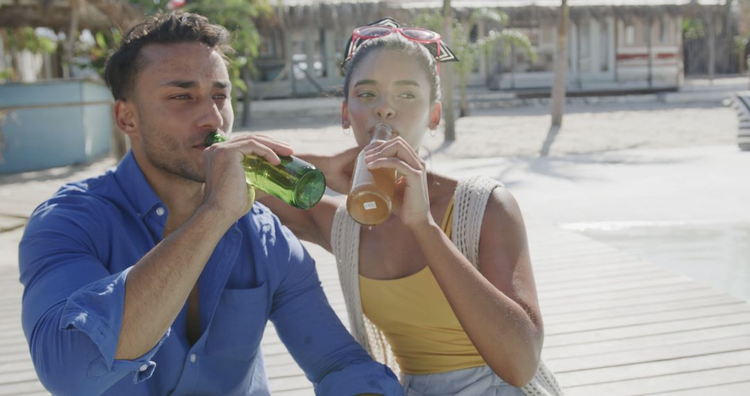 Biracial Couple Enjoying Drinks on Sunny Beach Pier