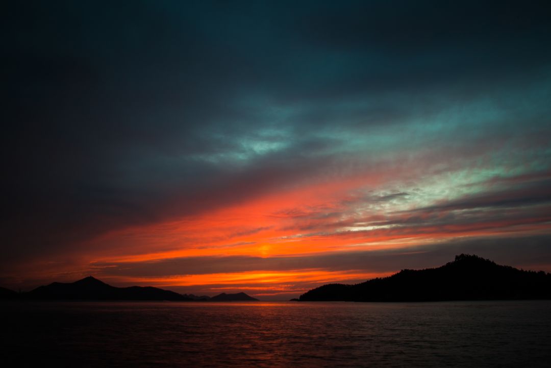 Stunning Sunset Over Serene Mountainous Sea - Free Images, Stock Photos and Pictures on Pikwizard.com