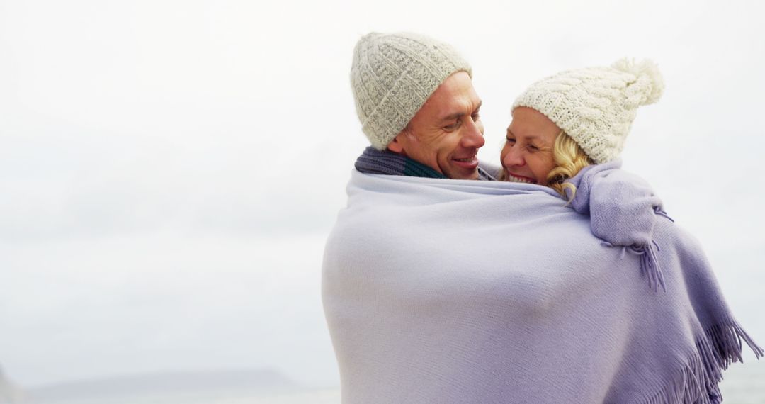 Middle-Aged Couple Embracing Under Cozy Blanket Outdoors - Free Images, Stock Photos and Pictures on Pikwizard.com