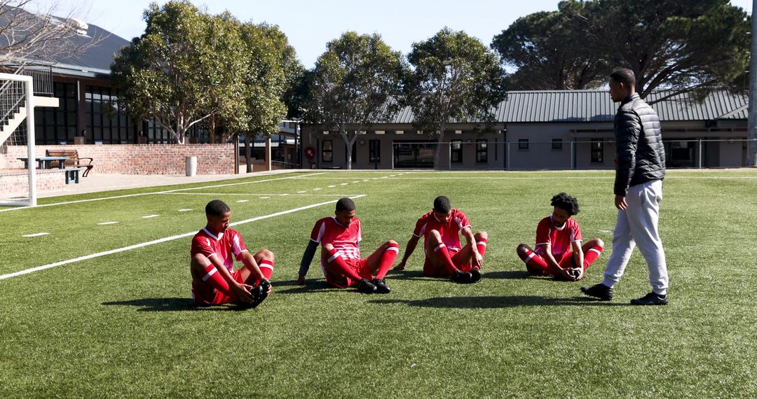 Soccer Coach Instructing Youth Team on Field During Training