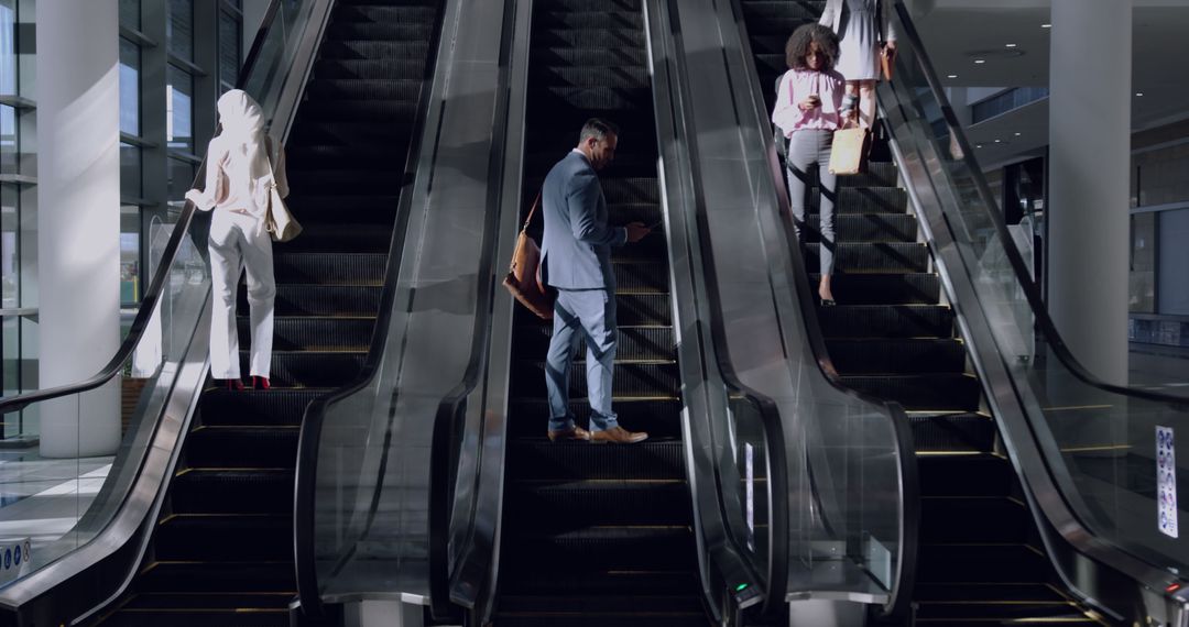 People Riding Escalators at Modern Office Building - Free Images, Stock Photos and Pictures on Pikwizard.com