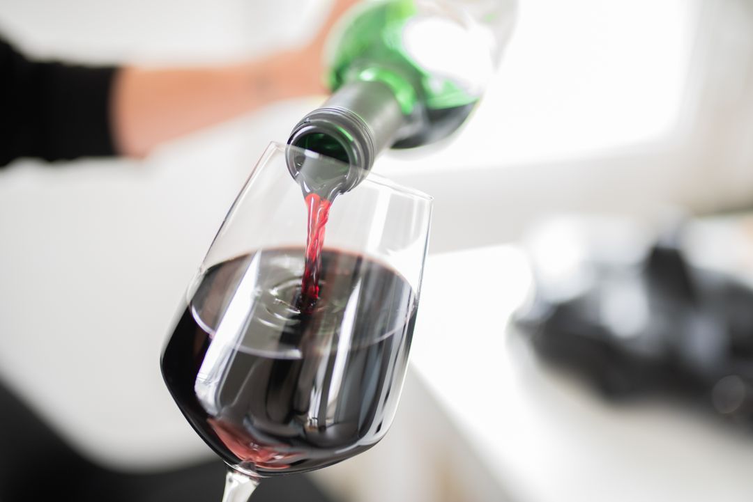 Pouring Red Wine into Glass in Soft Background Setting