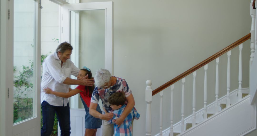 Grandparents Smiling and Greeting Embracing Wait Downstairs With Their Playfully Running Grandchildr - Free Images, Stock Photos and Pictures on Pikwizard.com