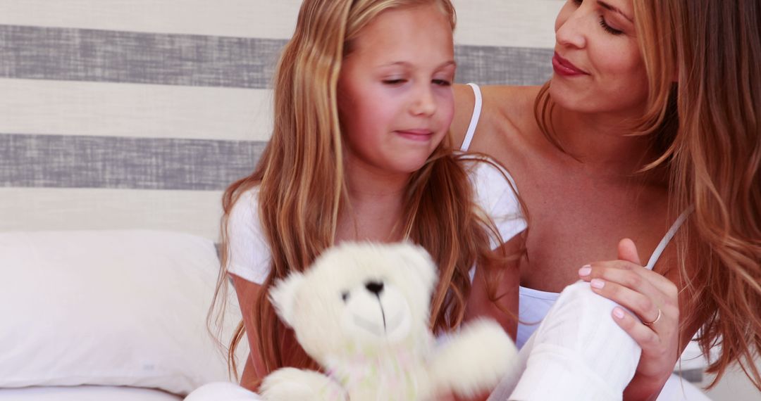 Mother and Daughter Bonding in Cozy Bedroom with Teddy Bear