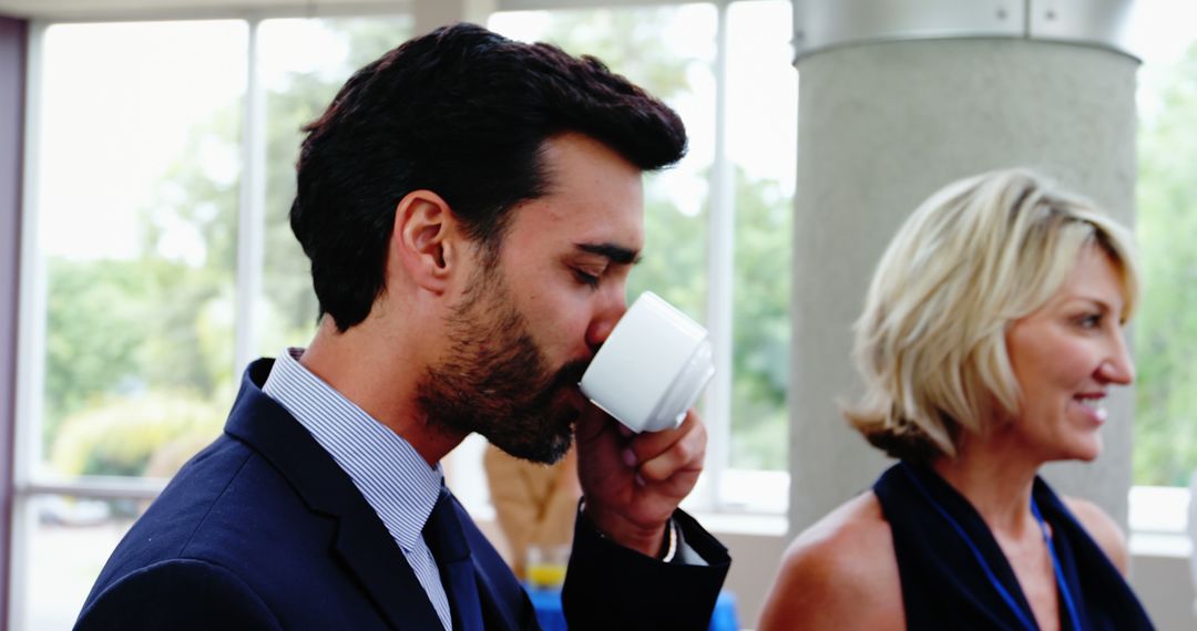 Businessman Drinking Coffee During Break in Office - Free Images, Stock Photos and Pictures on Pikwizard.com