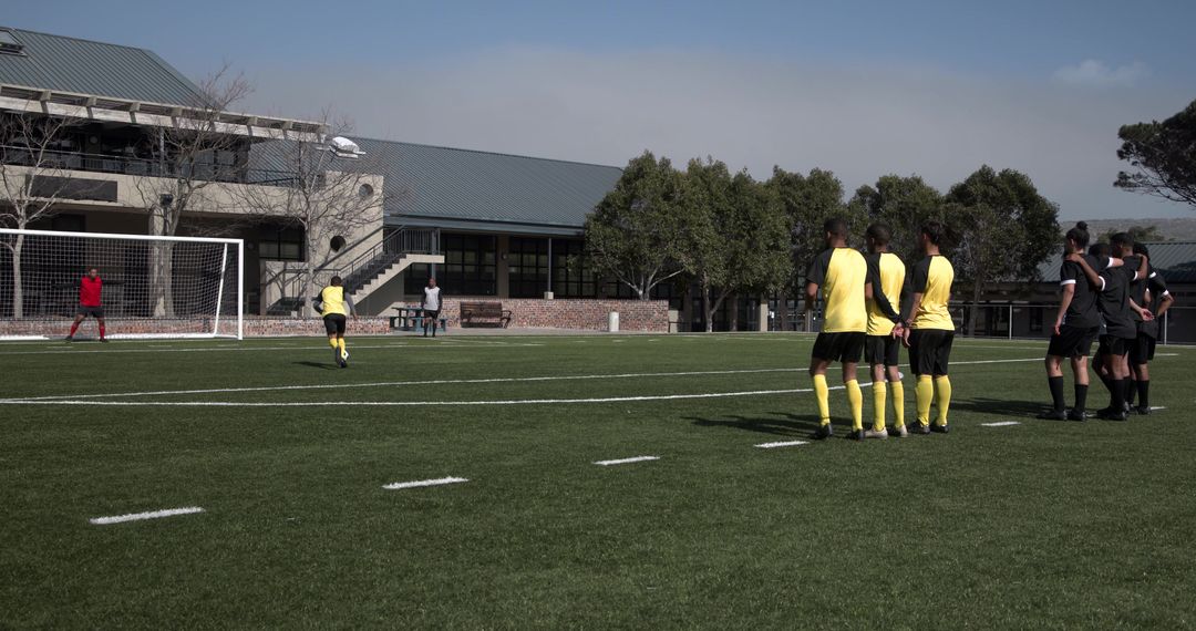 Soccer Penalty Kick with Players Watching on School Field
