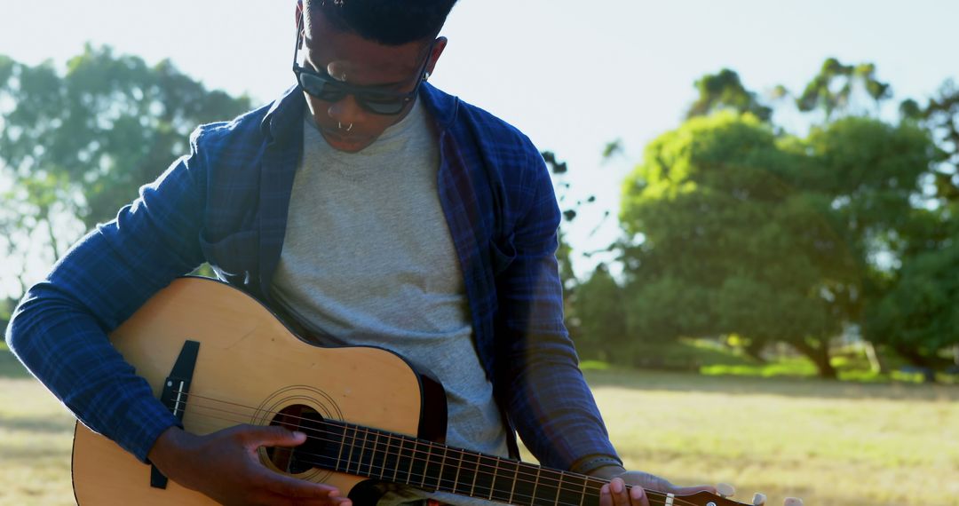 Young African American Man Playing Acoustic Guitar in Park on Sunny Day - Free Images, Stock Photos and Pictures on Pikwizard.com