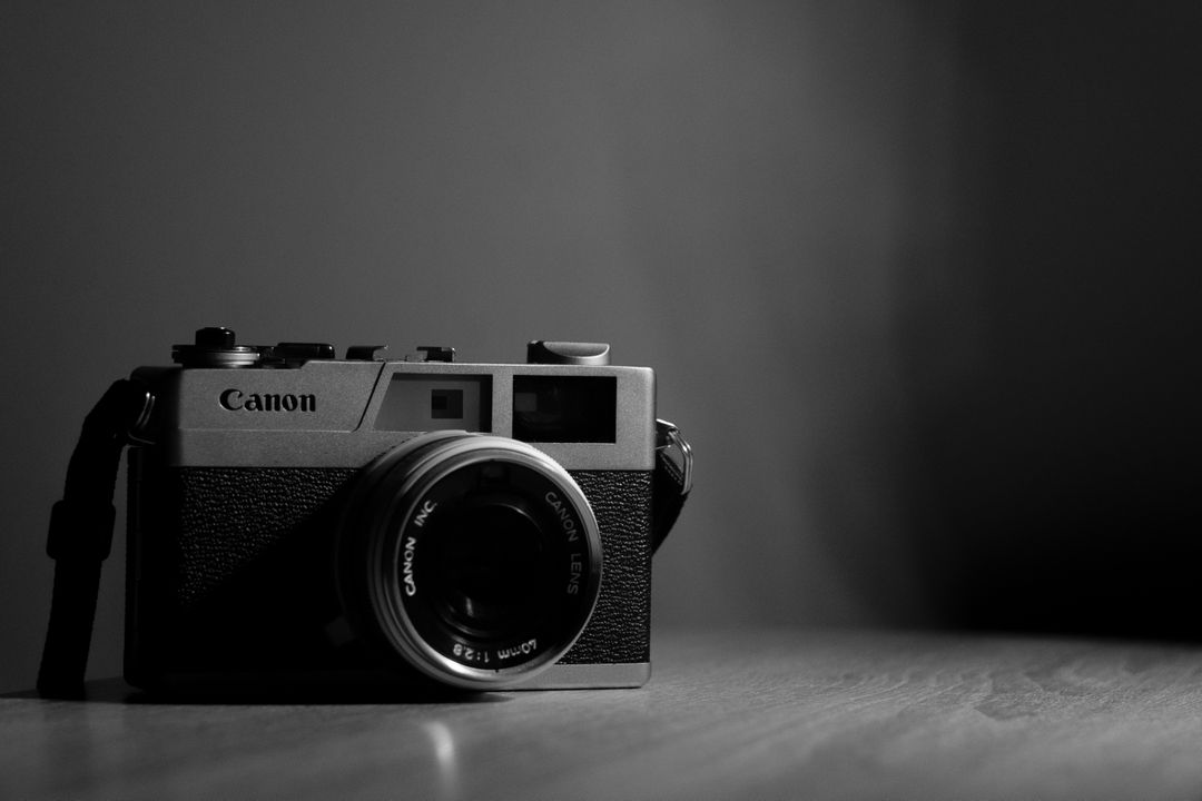 Vintage Canon Film Camera on Wooden Surface in Low Light - Free Images, Stock Photos and Pictures on Pikwizard.com