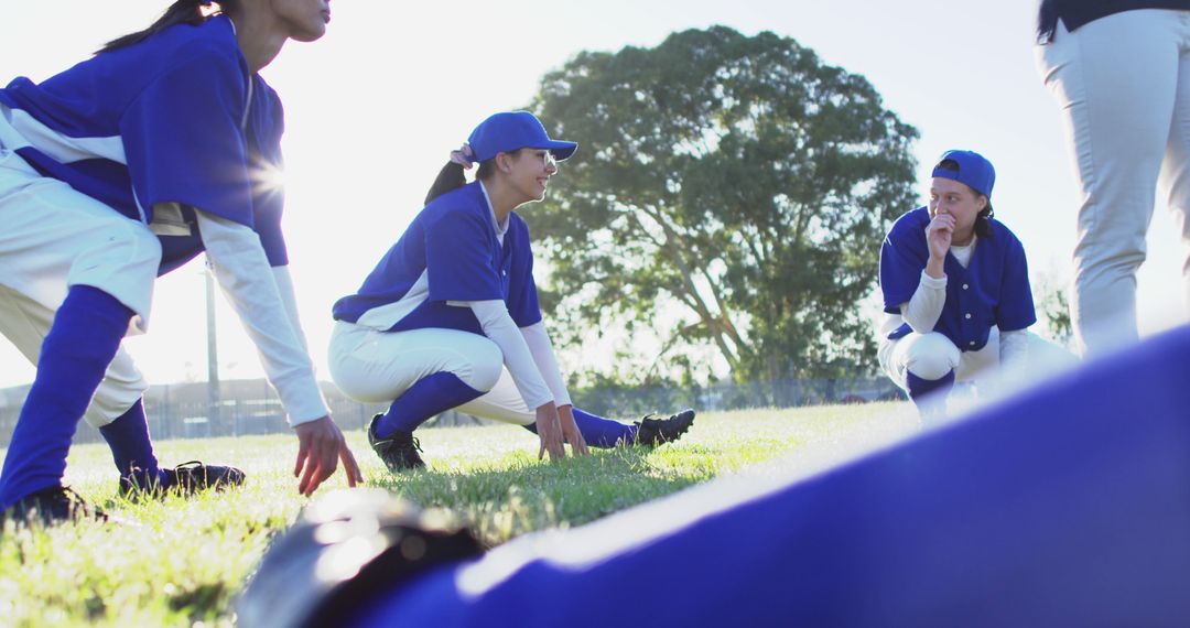 Female Baseball Players Stretching Together Outdoors - Free Images, Stock Photos and Pictures on Pikwizard.com