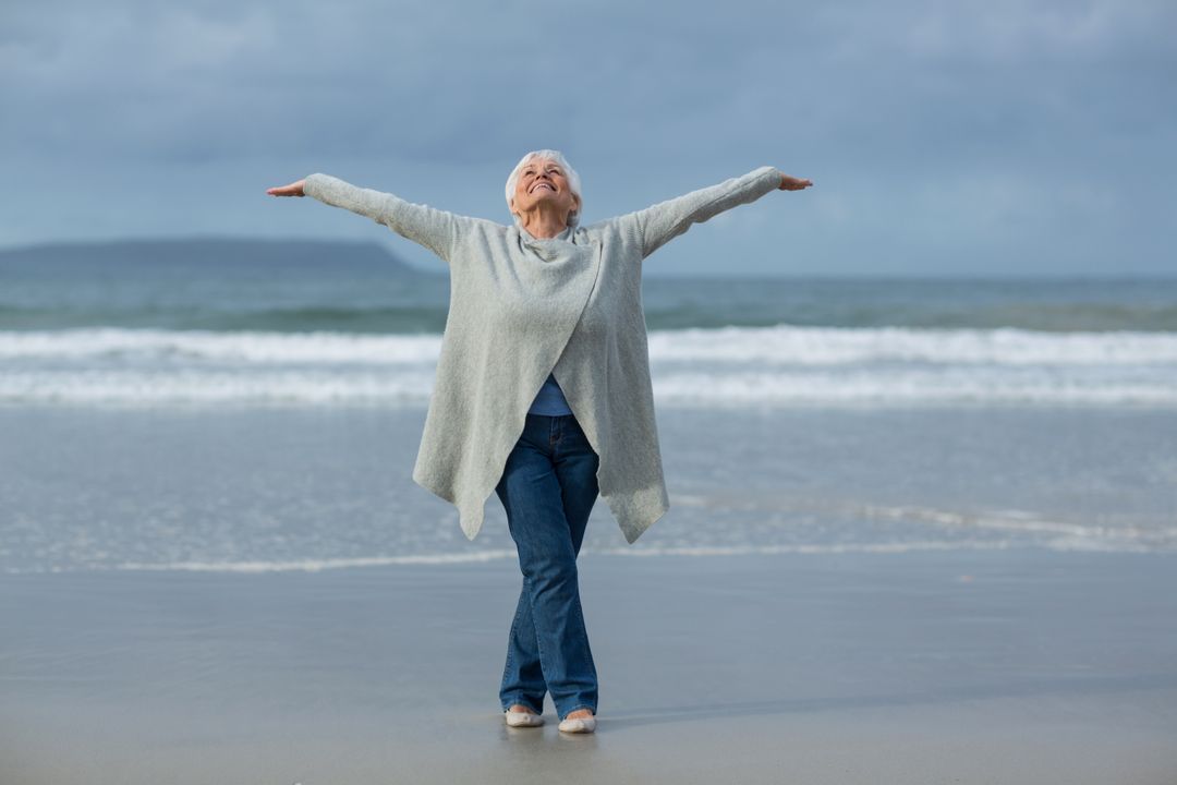 Senior Woman Enjoying Beach with Open Arms - Free Images, Stock Photos and Pictures on Pikwizard.com