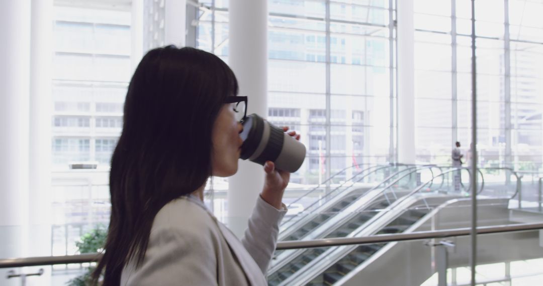 Businesswoman Drinking Coffee in Modern Office Building - Free Images, Stock Photos and Pictures on Pikwizard.com