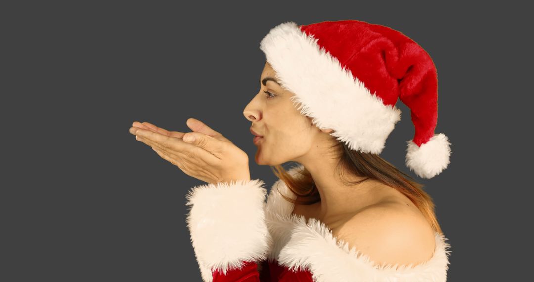 Woman Blowing Kiss in Santa Hat on Dark Background - Free Images, Stock Photos and Pictures on Pikwizard.com