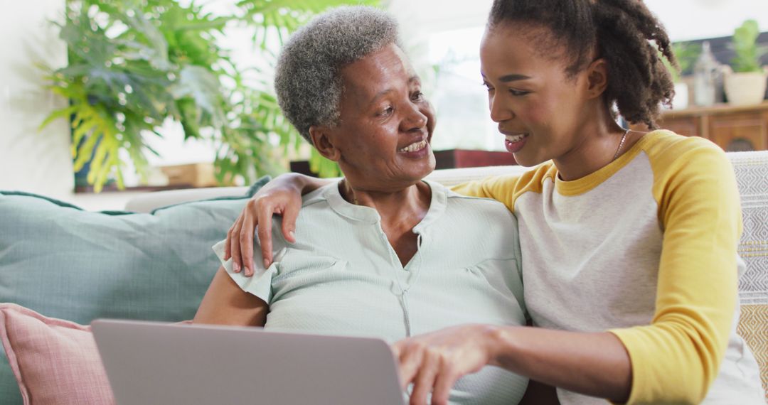 African American Grandmother and Adult Granddaughter Using Laptop Together on Sofa - Free Images, Stock Photos and Pictures on Pikwizard.com