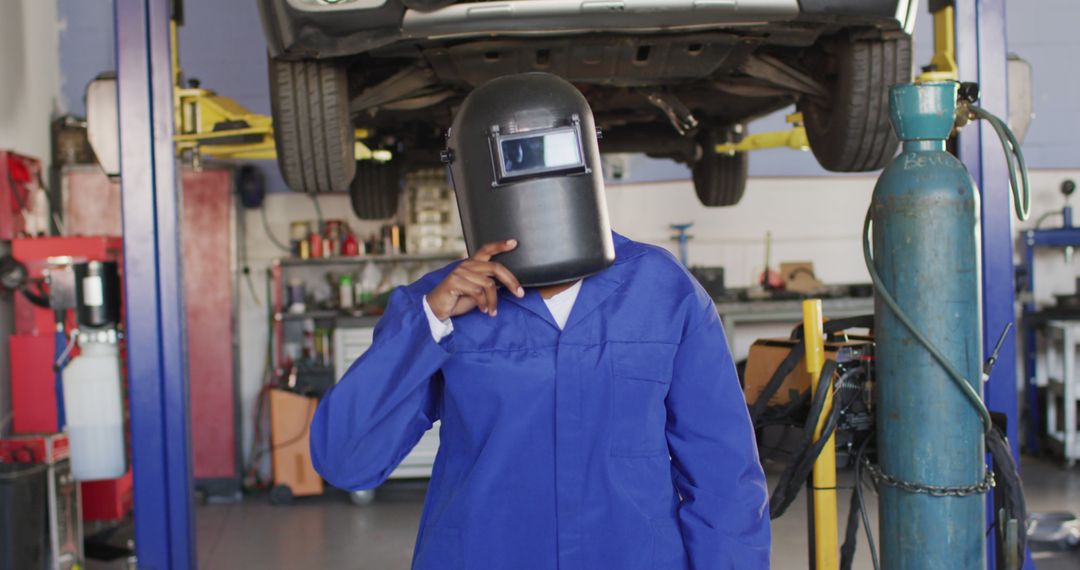 Mechanic Wearing Welding Helmet in Auto Repair Shop  - Free Images, Stock Photos and Pictures on Pikwizard.com