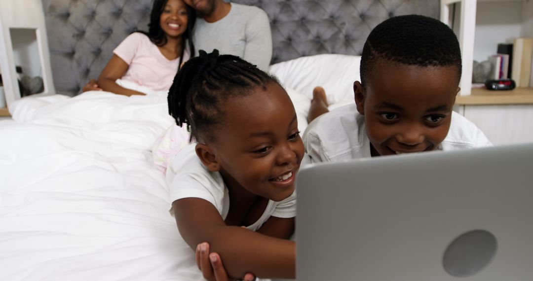 African American Family Relaxing with Children Using Laptop in Bed - Free Images, Stock Photos and Pictures on Pikwizard.com