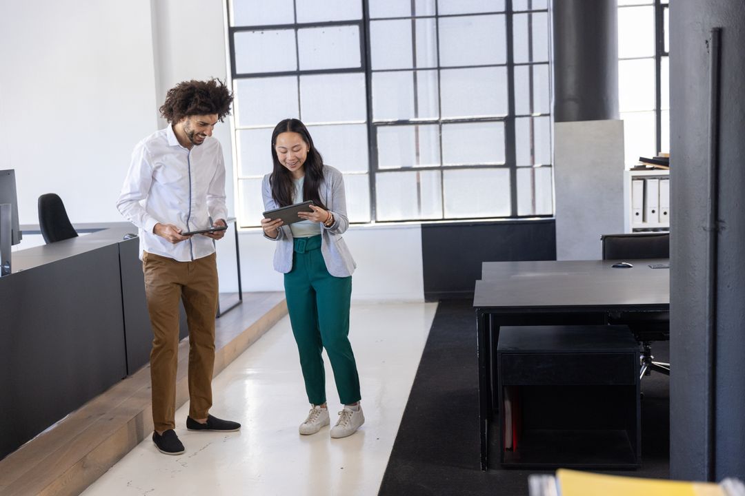 Diverse Team Collaborating on Tablets in Modern Office Setting