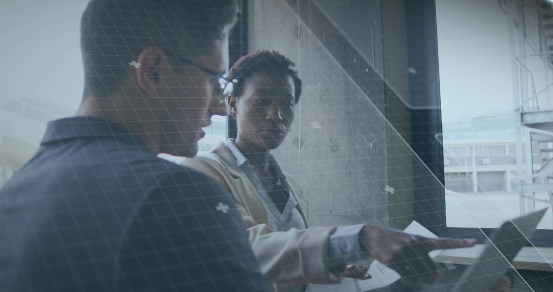 Collaborative Architectural Professionals Analyzing Plans at Site Window