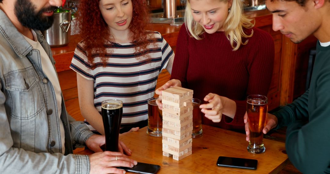 Young Adults Enjoying Social Jenga Game at Cozy Cafe