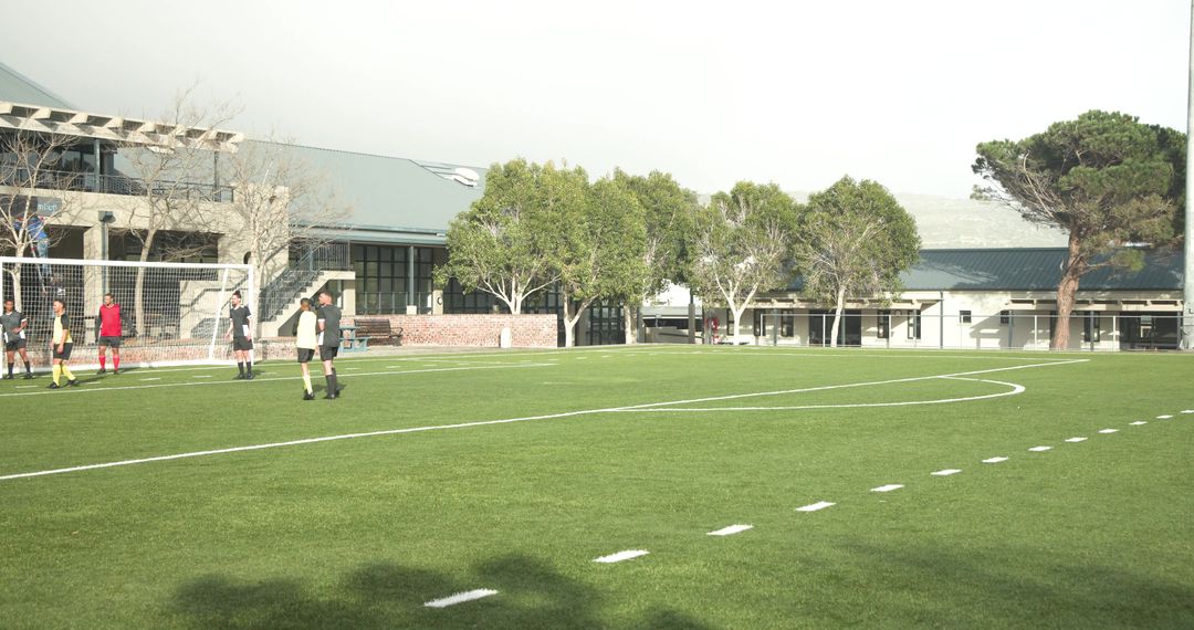 School Soccer Team Celebrating Goal on Field with High-Five Excitement