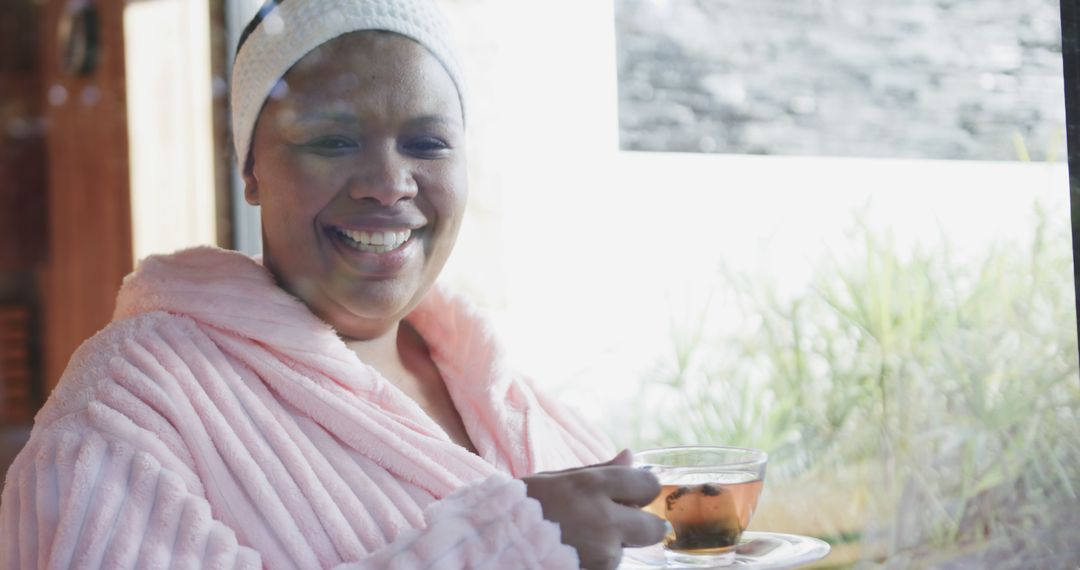 Woman Enjoying Hot Tea in Cozy Bathrobe by the Window - Free Images, Stock Photos and Pictures on Pikwizard.com