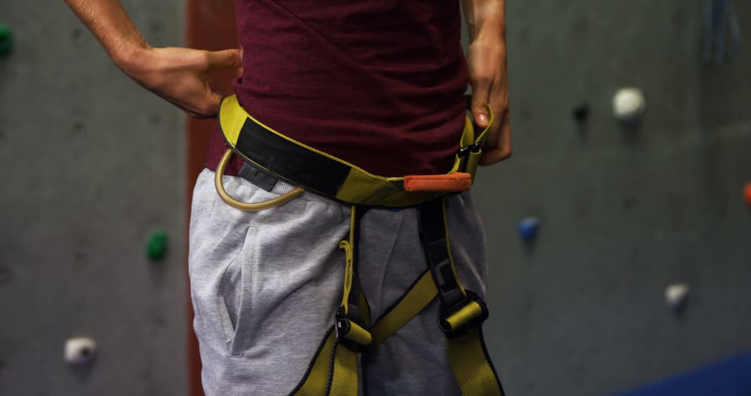 Individual Wearing Climbing Harness Preparing for Indoor Rock Climbing - Free Images, Stock Photos and Pictures on Pikwizard.com