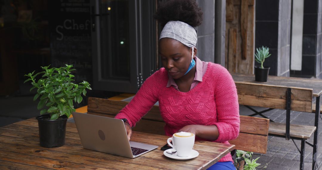 Woman Working On Laptop At An Outdoor Cafe With Coffee - Free Images, Stock Photos and Pictures on Pikwizard.com