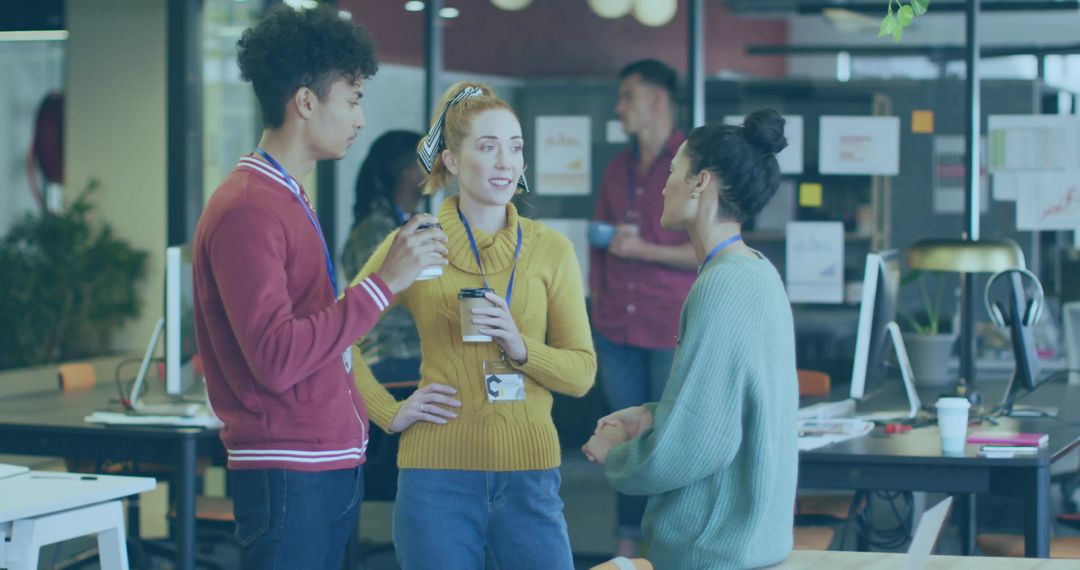 Young coworkers talking and drinking coffee in modern open office collaboration space
