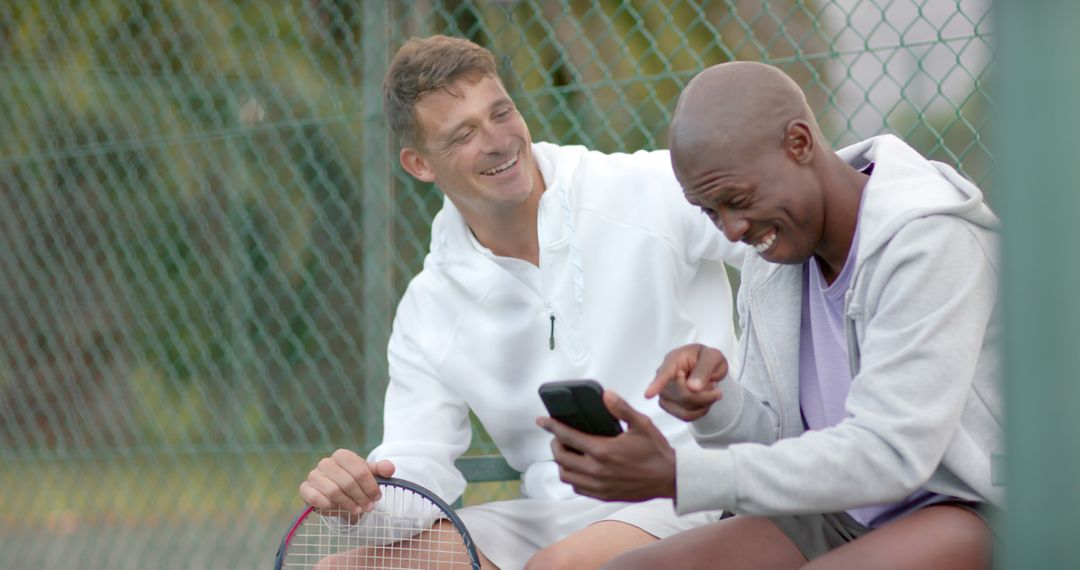 Two Friends Relaxing on Tennis Court Using Smartphone - Free Images, Stock Photos and Pictures on Pikwizard.com