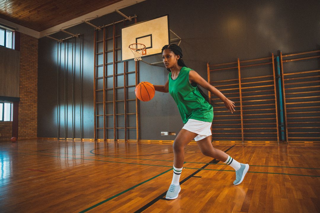 Biracial female basketball player practicing dribbling ball in court - Free Images, Stock Photos and Pictures on Pikwizard.com