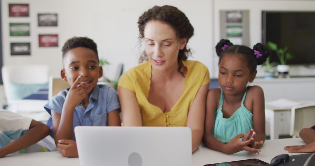 Image of happy caucasian female teacher and african american pupils using laptop - Free Images, Stock Photos and Pictures on Pikwizard.com
