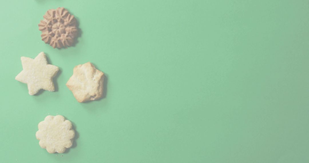Flat lay assortment of shortbread cookies on mint green backdrop with copy space