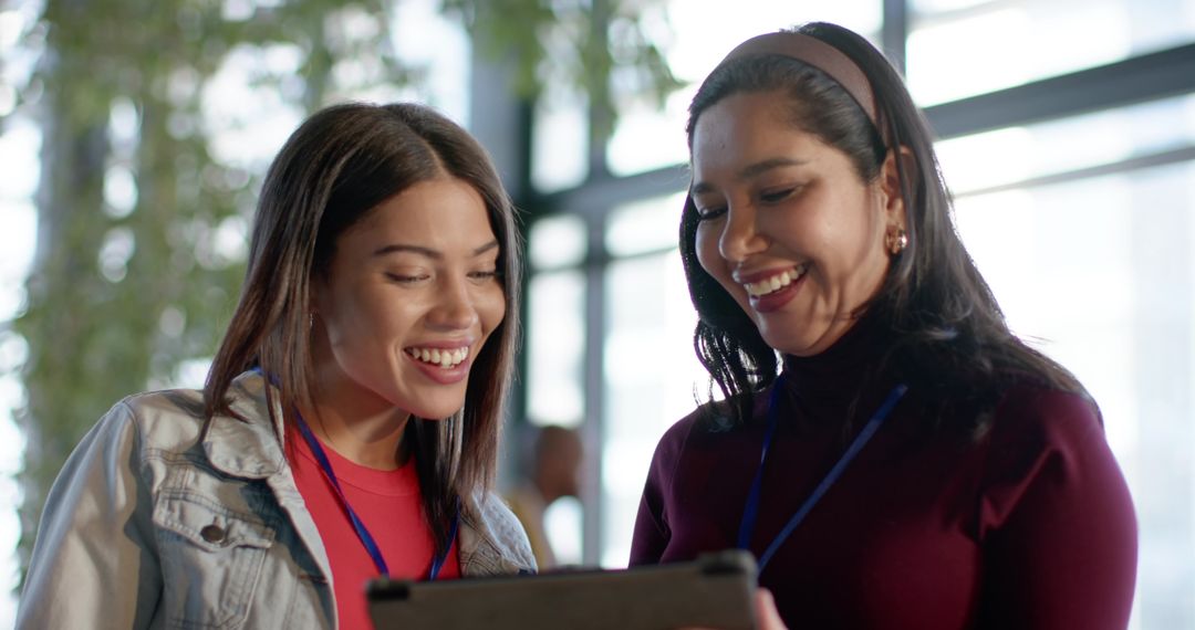 Multicultural professionals smiling and collaborating while viewing tablet at conference