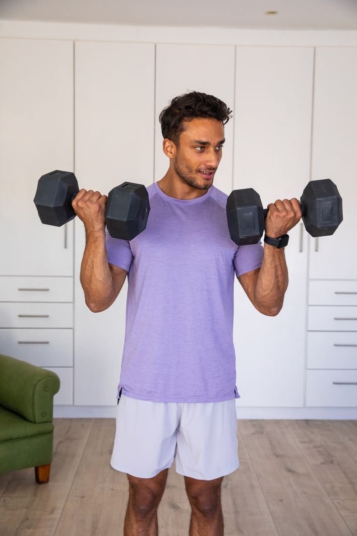 Man Exercising with Dumbbells in Home Gym Invokes Strength and Wellness