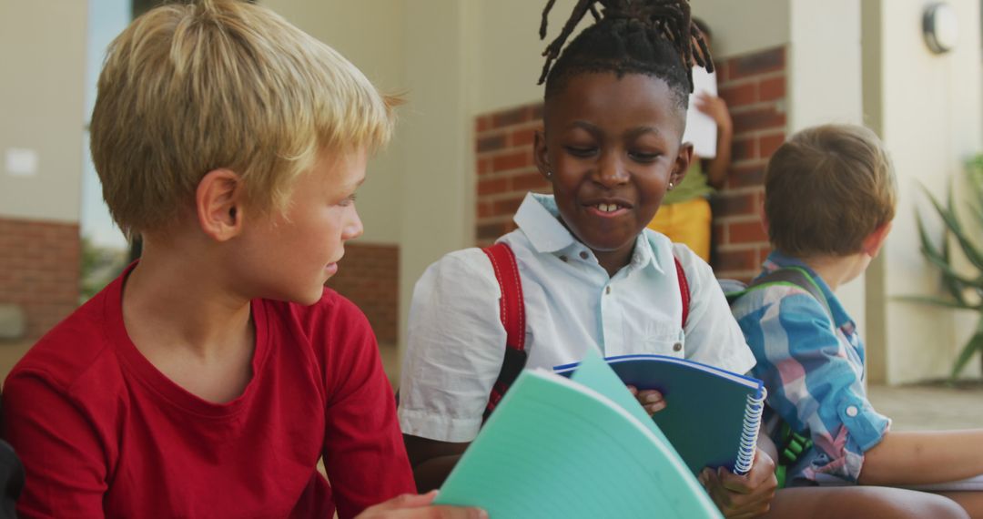 Diverse Children Smiling and Sharing Books in Schoolyard