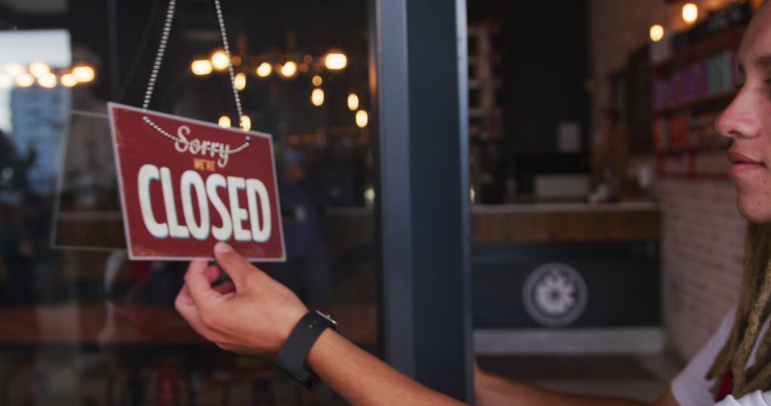 Smiling Barista Holds Closed Sign in Artesanal Café Setting