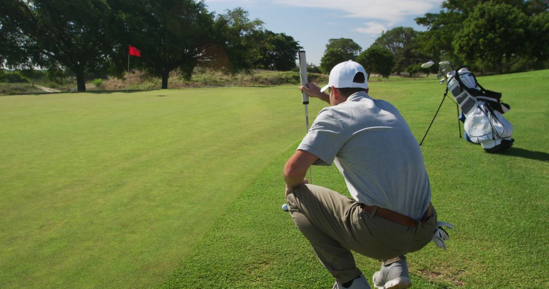 Golfer Analyzing Green with Flag in Background - Free Images, Stock Photos and Pictures on Pikwizard.com