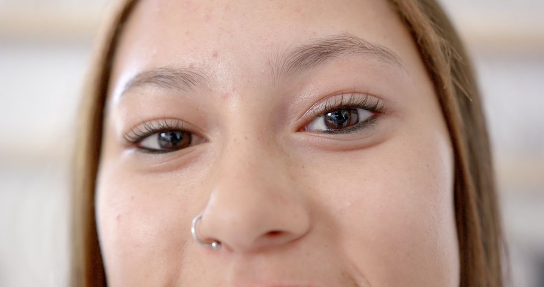Close-Up Portrait of Smiling Young Woman with Nose Piercing