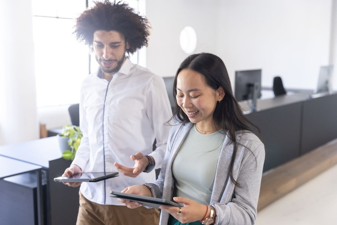 Diverse Coworkers Collaborating with Digital Tablets in Modern Office
